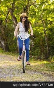 A beautiful and happy young woman riding her bicycle