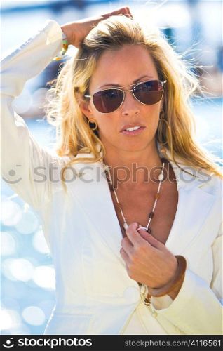 A beautiful and sophisticated young blond woman by the sea on a sunny summer day