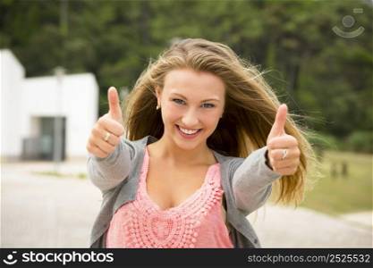 A beautiful and young girl smiling with thumbs up