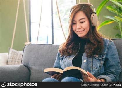 A beautiful asian woman enjoy listening to music with headphone while reading book