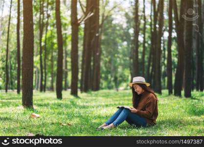A beautiful Asian woman reading a book while sitting in the park