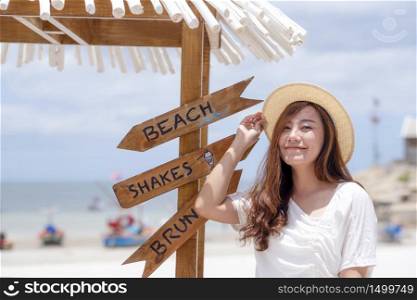 A beautiful asian woman with a white beach and sea in background