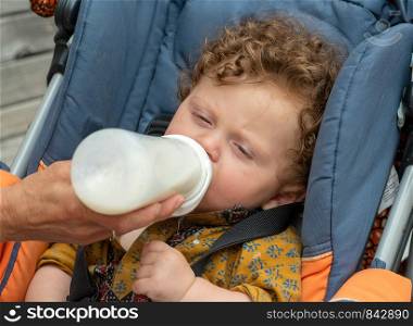 a beautiful baby drinking a milk bottle