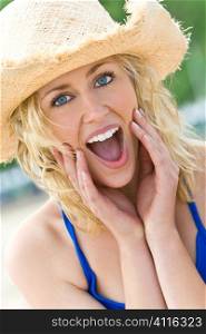 A beautiful blond haired blue eyed model wearing a straw cowboy hat and with a look of surprise shot with natural light