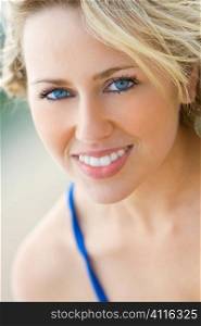 A beautiful blond haired blue eyed model with a gorgeous smile shot in close up with a short depth of field and illuminated with natural light