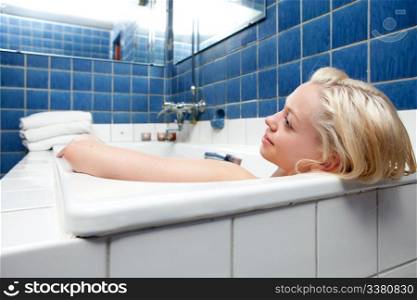 A beautiful blonde woman relaxing in a spa bath