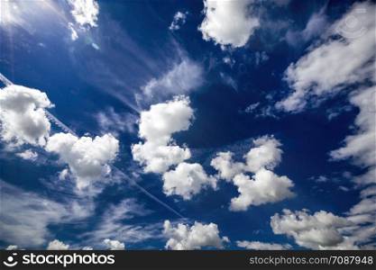 a beautiful blue sky lit with bright sunlight with white clouds of various shapes, a beautiful summer landscape. beautiful blue sky