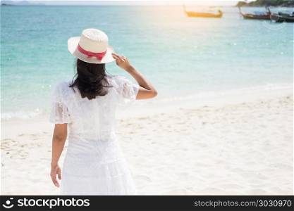 a beautiful carefree Woman relaxing at the beach enjoying her sun dress freedom wear. a beautiful carefree Woman relaxing at the beach enjoying her su