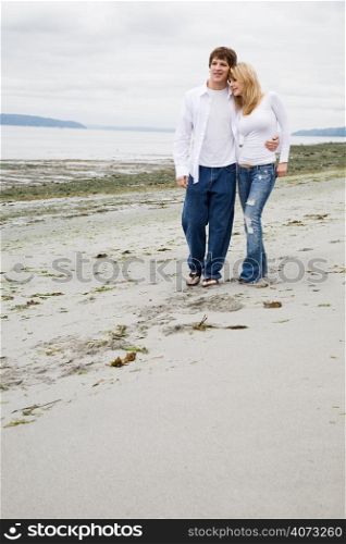 A beautiful caucasian couple in love walking on the beach