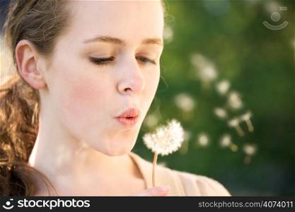 A beautiful caucasian summer teenage girl making a wish