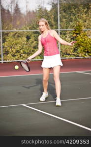 A beautiful caucasian tennis player hitting the ball on the tennis court