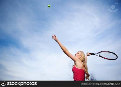 A beautiful caucasian tennis player serving the ball on the tennis court
