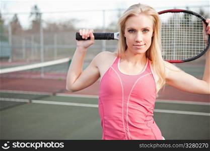 A beautiful caucasian tennis player stretching on the tennis court