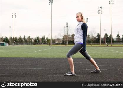 A beautiful caucasian woman exercises in a sport field