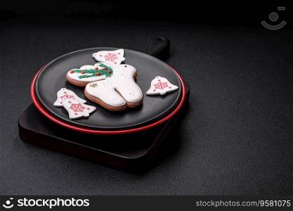 A beautiful Christmas composition consisting of ceramic plates, gin≥rbread and other e≤ments of New Year’s decorations on a dark concrete background