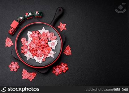 A beautiful Christmas composition consisting of ceramic plates, gingerbread and other elements of New Year&rsquo;s decorations on a dark concrete background