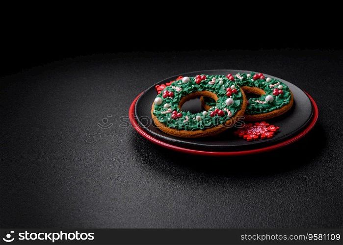 A beautiful Christmas composition consisting of ceramic plates, gingerbread and other elements of New Year’s decorations on a dark concrete background