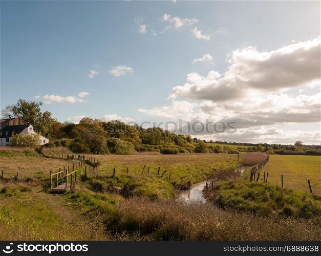 a beautiful countryside scene with small stream and lush vibrant colours