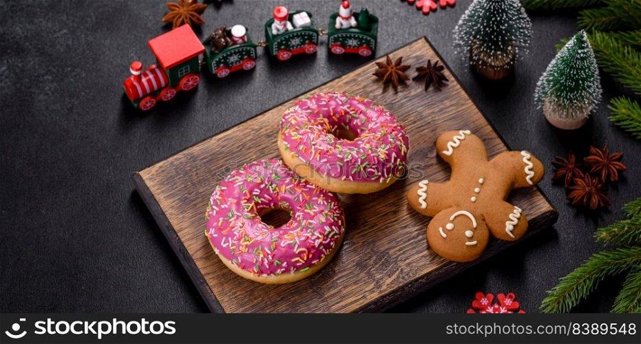 A beautiful doughnut with pink glaze and colored sprinkle on a dark concrete background. Sweets to the christmas table. A beautiful doughnut with pink glaze and colored sprinkle on a christmas table