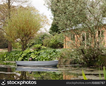 A Beautiful Garden With Trees and Plants and Lake in the Spring in the Uk with people and reflections