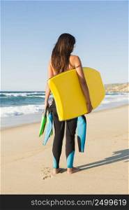 A beautiful girl at the beach with her bodyboard