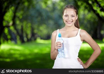 A beautiful girl with a bottle of water in the park