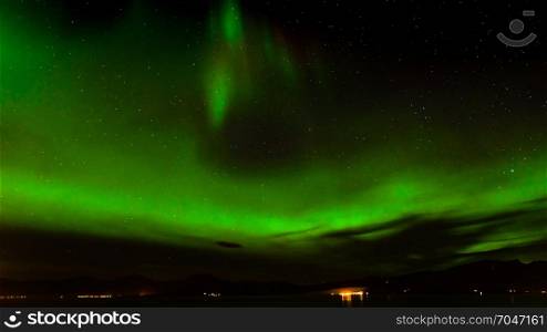 A beautiful green Aurora borealis or northern lights in the sky at Tromso, Norway