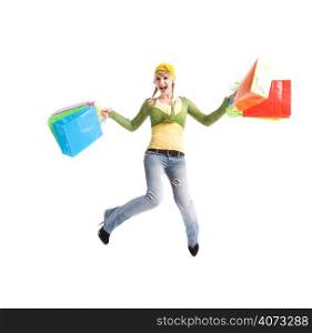 A beautiful happy caucasian girl jumping and carrying shopping bags