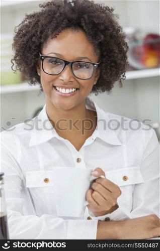 A beautiful happy mixed race African American girl or young woman drinking coffee with a cafetiere in her kitchen at home