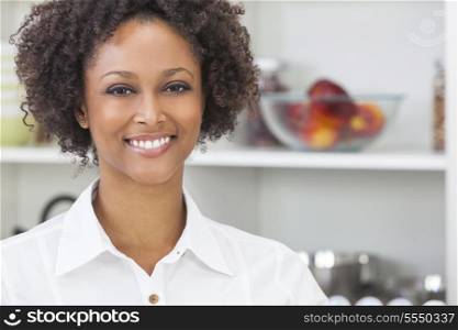 A beautiful happy mixed race African American girl or young woman using in her kitchen with fresh fruit