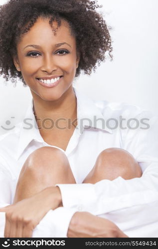 A beautiful happy mixed race African American girl or young woman wearing a white shirt smiling with perfect teeth