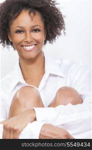 A beautiful happy mixed race African American girl or young woman wearing a white shirt smiling with perfect teeth