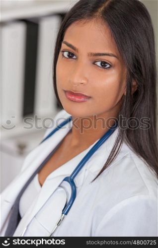 A beautiful Indian Asian female medical doctor in a hospital office happy and smiling with stethoscope&#xD;