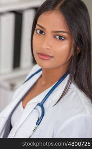 A beautiful Indian Asian female medical doctor in a hospital office happy and smiling with stethoscope&#xD;