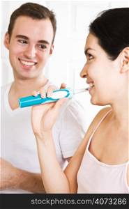 A beautiful interracial couple in the bathroom brushing teeth
