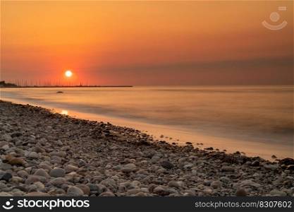 A beautiful long exposure sunset on a rocky beach on the Baltic Sea in Germany