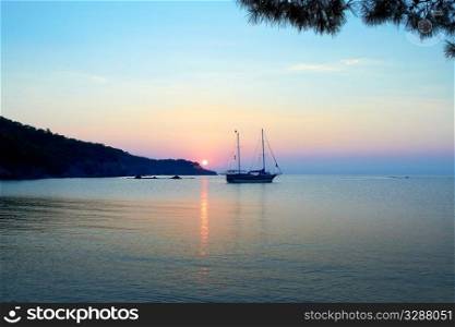 A beautiful Mediterranean sea sunrise with alone ship in the foreground.