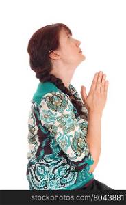 A beautiful middle age woman sitting in profile and praying with herhands felted, isolated for white background.
