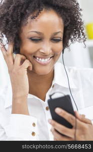 A beautiful mixed race African American girl or young woman listening to music on mp3 player and headphones