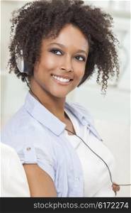 A beautiful mixed race African American girl or young woman listening to music on mp3 player and headphones