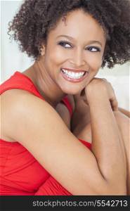 A beautiful mixed race African American girl or young woman wearing a red dress looking happy and smiling with perfect teeth