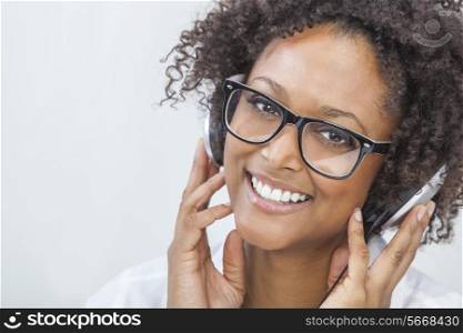 A beautiful mixed race African American girl or young woman wearing glasses and listening to music on mp3 player and headphones