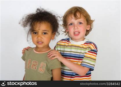 A beautiful mixed race girl and a blonde boy stand together