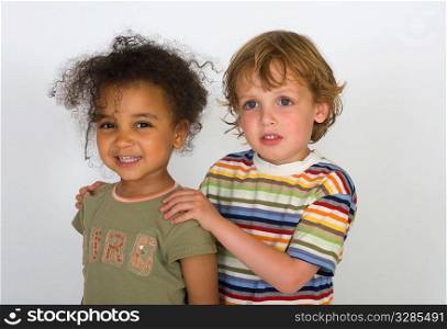 A beautiful mixed race girl and a blonde boy stand together