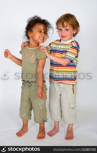 A beautiful mixed race girl and a blonde boy stand together laughing