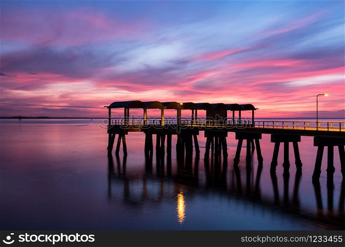 A beautiful ocean dramatic sunset and fishing pier at Jekyll Island in coastal Georgia, USA.