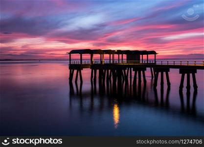 A beautiful ocean dramatic sunset and fishing pier at Jekyll Island in coastal Georgia, USA.