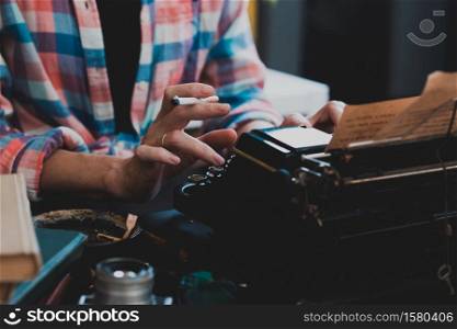 a beautiful old retro typewriter close-up, hands and a cup of coffee