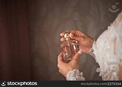 A beautiful perfume bottle in the palms of a girl.. A bottle of perfume in womens hands 4261.