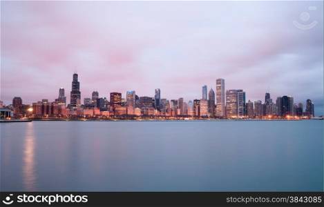 A beautiful pink sunrise lights the long downtown Chicago skyline